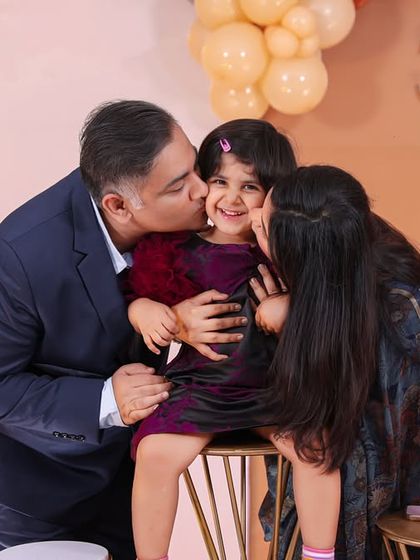 Surrounded by love. A beautiful, happy moment as the birthday girl gets kisses from both mom and dad.