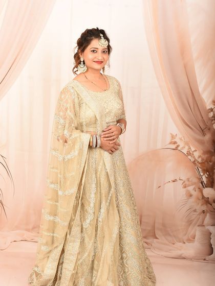 A beautiful studio portrait of a woman in a traditional lehenga, looking confidently at the camera.