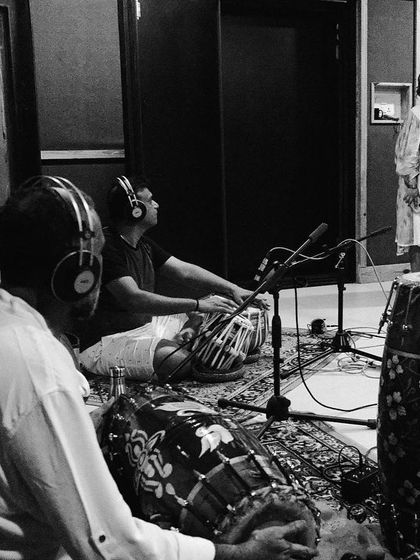 A candid black and white photo from a rehearsal, showing the intense focus and collaboration between the musicians.