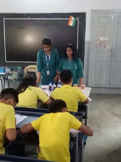 Instructors at the front of the classroom during the competition, overseeing the event and supporting the students.