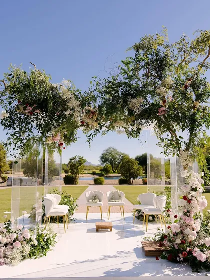The stunning outdoor mandap, framed by a lush floral arch. The design of the ceremony programs was inspired by this beautiful, natural setting.