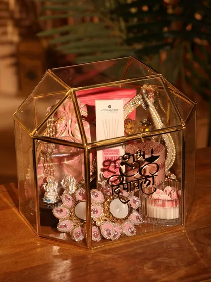 This is one of my favorite Diwali hampers, designed to feel both luxurious and festive. It’s housed in a stunning gold-trimmed glass terrarium and filled with handpicked items like decorative diyas, gourmet treats, and personalized elements.