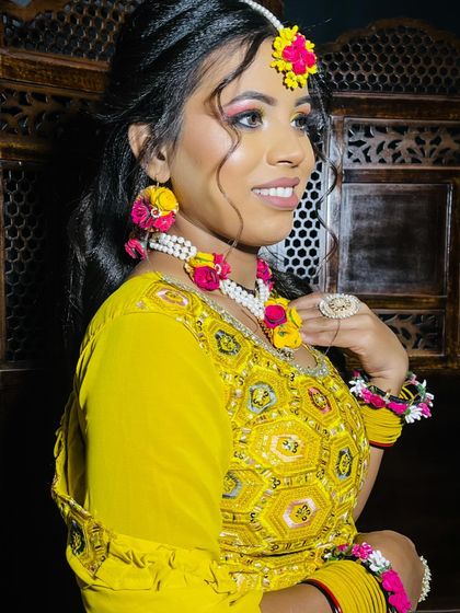 A bright and joyful Haldi look, featuring yellow floral jewelry and vibrant eye makeup.