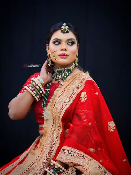 Reviving the art of traditional Indian makeup. This look features bold, kohl-rimmed eyes, a classic red lehenga, and rich green jewelry for a truly regal feel.