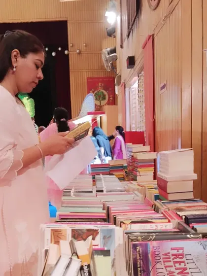 A parent thoughtfully browses the books at our stall. School fairs are a great opportunity for us to connect with the wider community of parents and educators.