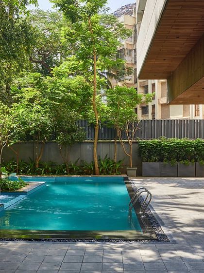The residential pool and jacuzzi area, designed for both leisure and exercise, is surrounded by lush landscaping and features a calming water cascade.