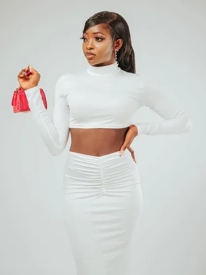 A confident three-quarter pose. The white-on-white look is very chic and modern.