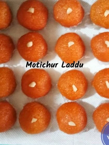 These are our Motichur Laddus, made from tiny droplets of gram flour batter fried in ghee and then soaked in sugar syrup. Each laddu is soft, juicy, and garnished with a piece of nut.