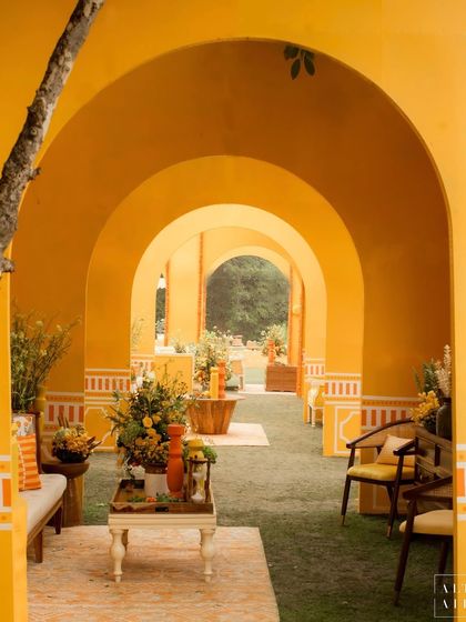 A striking architectural element from the 'Kesar Sehar' Haldi: a corridor of vibrant yellow arches with hand-painted details, creating a powerful visual statement.