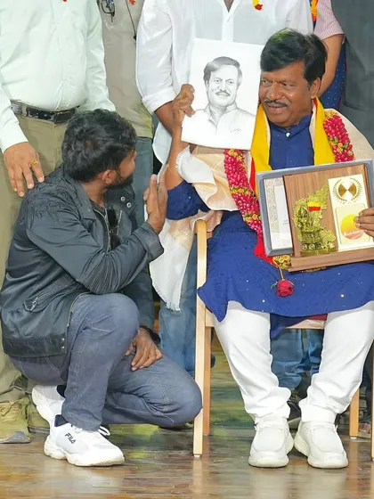 A candid moment on my knees, presenting a live sketch to an honored guest on stage.