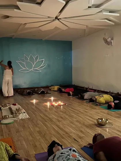 Here I am facilitating a sound bath, with participants resting deeply. The combination of candlelight and the studio's calming ambiance enhances the healing experience.