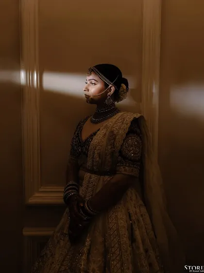 A moody and artistic portrait of the bride, using shadows and a single light source to create a dramatic effect.