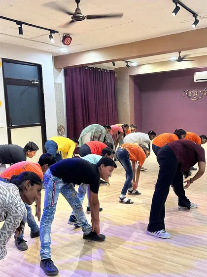 The kids participating in a warm-up stretch during the dance workshop held at our studio.
