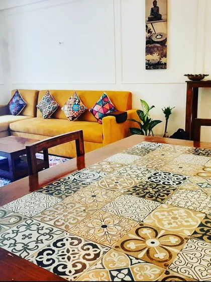 We love adding unique, personal touches. For this living room, we refurbished the client's existing dining table by adding a custom top with a mosaic of Moroccan-style tiles, turning it into a statement piece that anchors the room.