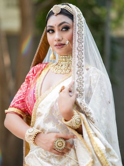 A gorgeous and subtle makeup look on a model in a beautiful white and red saree, perfect for a modern take on a traditional look.