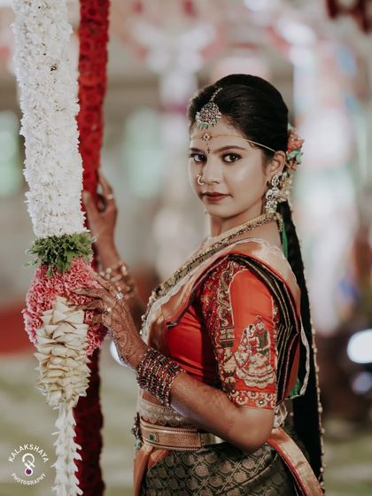 A stunning portrait of a bride in her traditional wedding attire, looking directly at the camera.