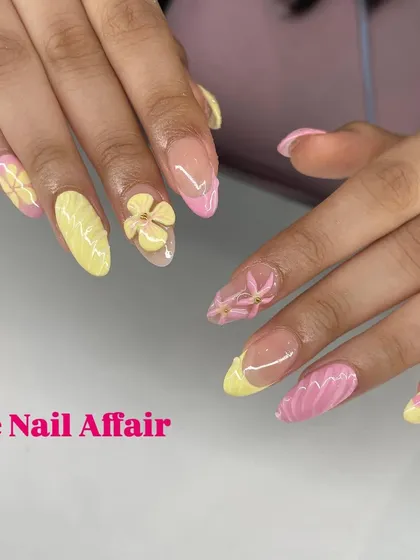 A playful and textured manicure combining yellow and pink nails with 3D flowers and ridged patterns.