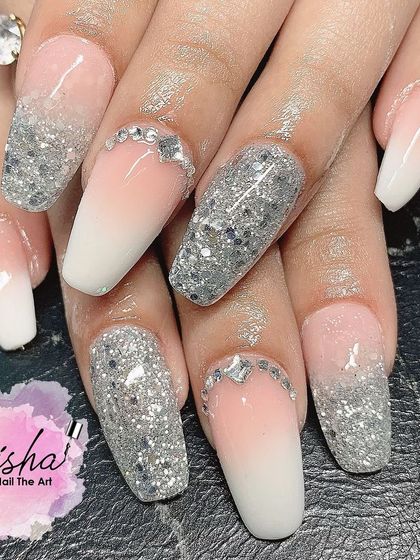 A glamorous set of baby boomer nails with full silver glitter accent nails and rhinestone details.