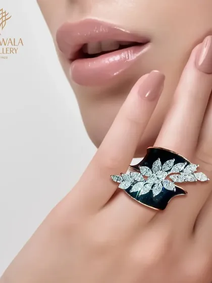 A unique ring design with two leaf-like motifs in black enamel and diamonds, creating a striking and artistic statement.