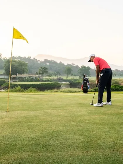 A player lines up a crucial putt on the green. We focus on teaching green reading, pace control, and a consistent putting stroke to help you sink more putts.