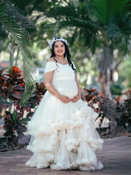 Our white ruffled gown is a popular choice for maternity shoots. The off-shoulder design and voluminous skirt create a classic and angelic look for the mom-to-be.