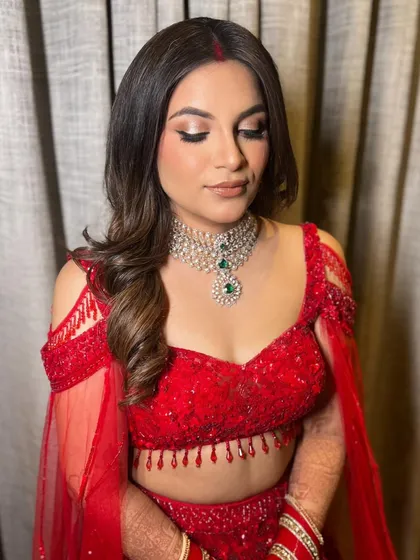 This close-up highlights the soft, romantic feel of the hairstyle, which pairs perfectly with the sparkling red outfit.
