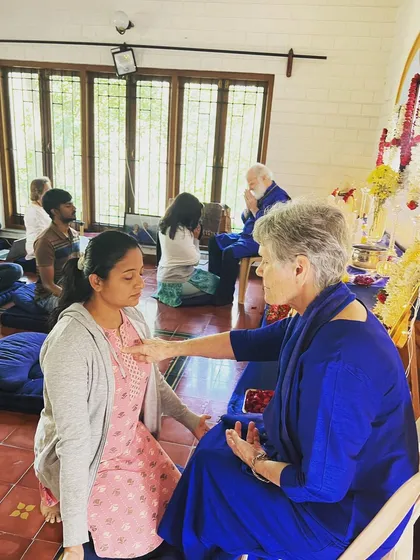 Receive the Guru's blessing. A moment from a purification ceremony, where a devotee is guided to release inner blocks and open her heart to divine grace.