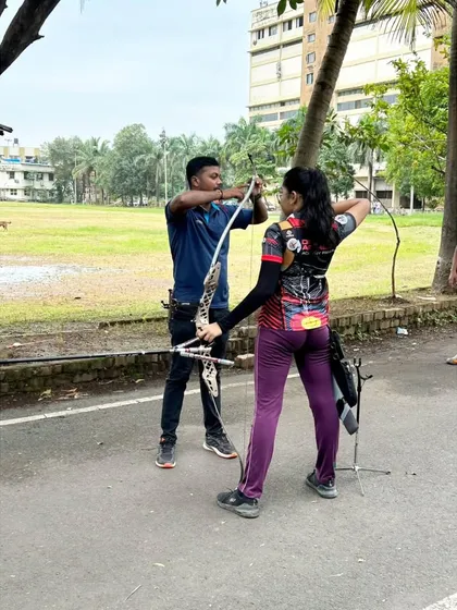 Here I am assisting a student with her recurve bow setup during a practice session. We make sure every archer, new or experienced, understands their equipment and how to use it safely.
