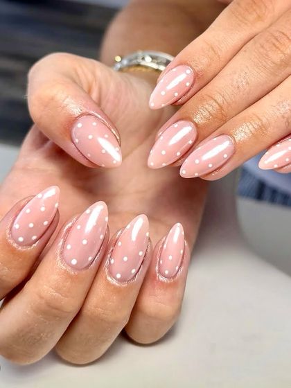 When life gives you dots, wear them on your nails. A classic and cute set of sheer pink nails with tiny white polka dots, perfect for a simple yet playful look.