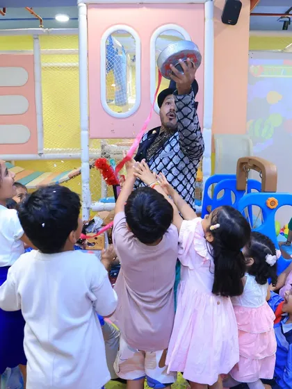A magician entertains the children at a mermaid-themed party. We can add entertainment like magic shows to any of our party themes.