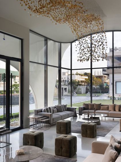 In this modern outhouse, we used seamless glass walls to dissolve the boundary between the living area and the garden. The double-height windows offer boundless views, making nature an integral part of the interior design and filling the space with light.