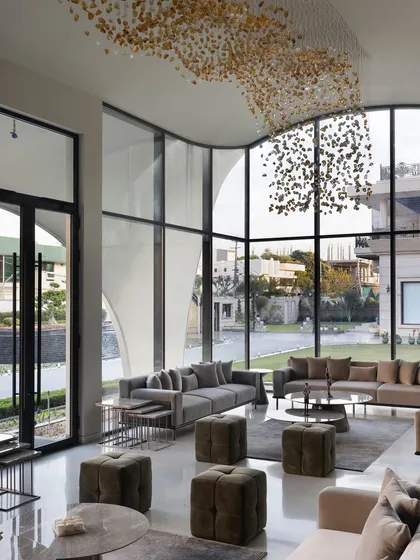 In this modern outhouse, we used seamless glass walls to dissolve the boundary between the living area and the garden. The double-height windows offer boundless views, making nature an integral part of the interior design and filling the space with light.