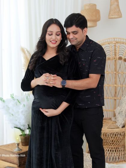 A standing portrait that showcases the couple's loving bond. His hands gently holding hers over the baby bump is a classic and heartfelt maternity pose.
