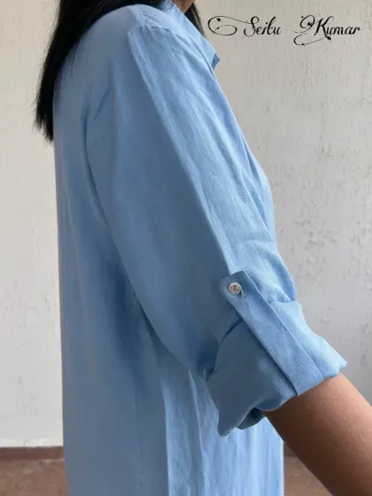 A close-up on the sleeve detail of the blue shirt dress, showing the quality craftsmanship and thoughtful design.