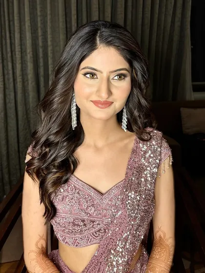 A full view of this sangeet bride's look. The shimmering lavender saree is paired with soft, glowing makeup and elegant cascading earrings.
