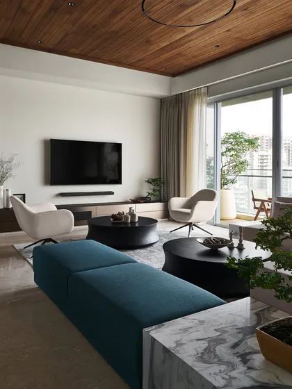 The vibrant teal bench adds a cool contrast to the warm wooden ceiling and neutral tones. My custom "Pivot" swivel armchairs and "Orbit" coffee tables work together to create a modern retreat that is both inviting and refined.