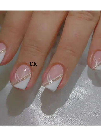 A close-up of the geometric French design, highlighting the clean lines and the touch of sparkle from the gold glitter.