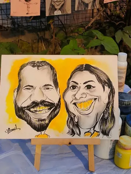 My artwork on display at an event. This quick couple caricature, with its bright yellow background, adds a splash of color and fun to my table setup.