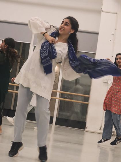 A student lost in the moment, dancing with a dupatta during a Bollywood routine. We often use props to make the choreography more expressive.