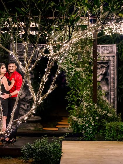 The illuminated trees provide a beautiful and subtle backdrop for a romantic couple's portrait in the garden.