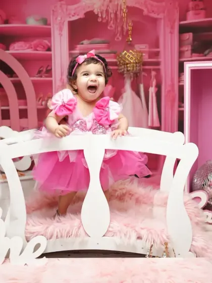 A vibrant and exciting first birthday shoot with a Barbie theme. The all-pink set includes a doll box, disco balls, and a "One" sign for a truly memorable celebration.