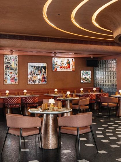 The main dining hall at Idylll, where curated art and custom lighting create a sophisticated yet comfortable ambiance. The material palette is consistently warm and earthy.