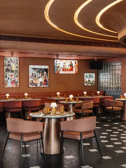 The main dining hall at Idylll, where curated art and custom lighting create a sophisticated yet comfortable ambiance. The material palette is consistently warm and earthy.