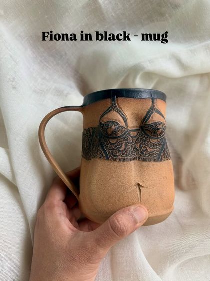 Here is the 'Fiona' mug in black, offering a bolder take on the design. The contrast between the dark carving and the natural clay body highlights the intricate linework.