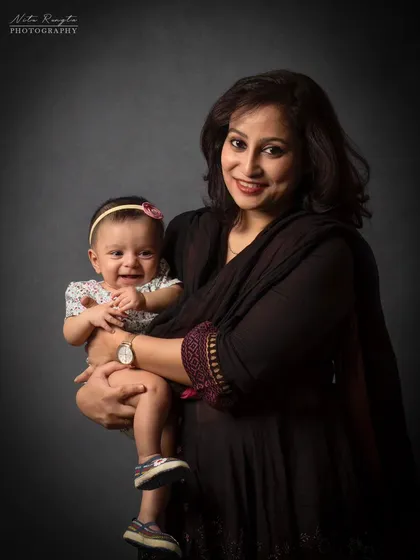 A mother's happy place. This beautiful portrait of a mother holding her smiling baby is a simple, classic, and heartwarming image.