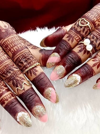 Bridal glam on point. From the intricate mehndi to the sparkling gold glitter nails and dainty rings, every detail here screams elegance and celebration.