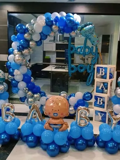 A 'Baby Boy' welcome home decoration with balloon columns, 'BABY' foil letters, and a balloon arch.