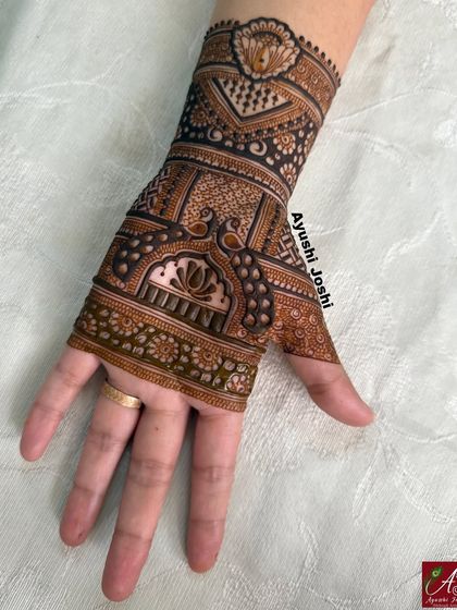 A short but intricate design for the back of the hand, featuring a peacock and lotus.