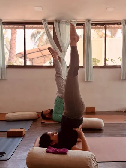 Students practice a supported shoulder stand variation during our workshop. Using props like bolsters makes inversions accessible and allows for a deeper restorative experience.