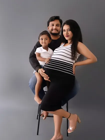 A modern family portrait with mom, dad, and their little one, showcasing a relaxed and happy family dynamic.
